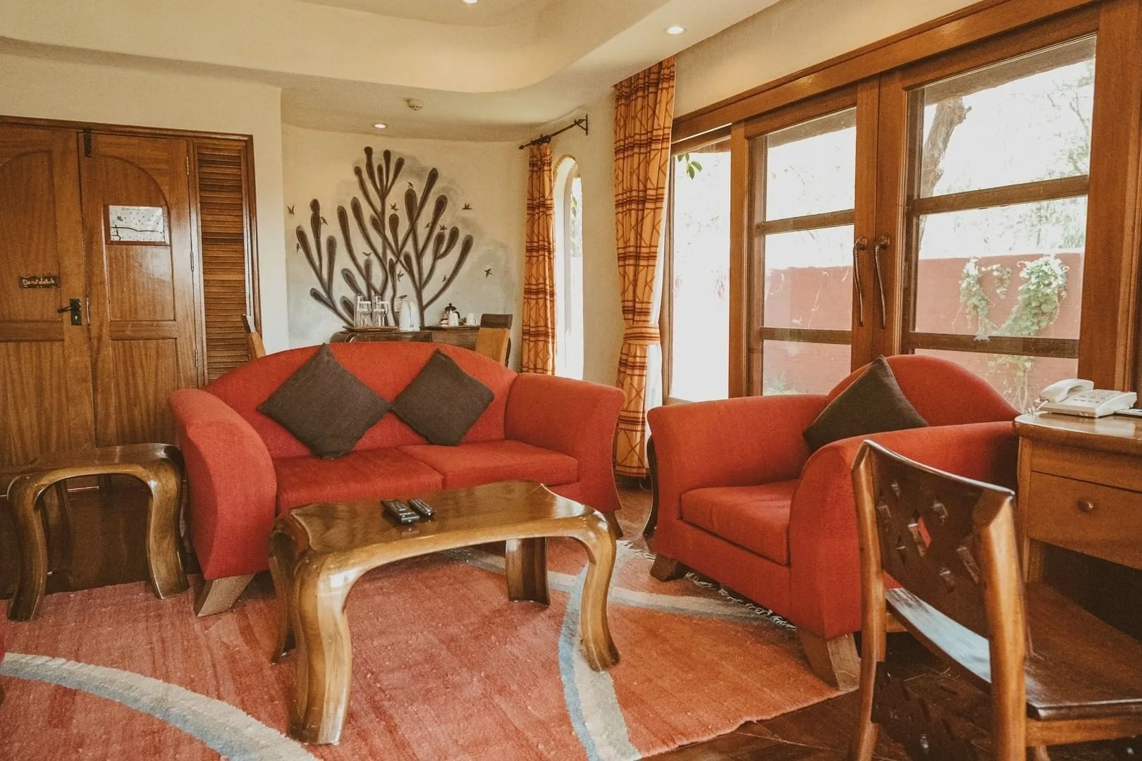 A spacious suite sitting area decorated with Maasai-inspired wildlife artwork.