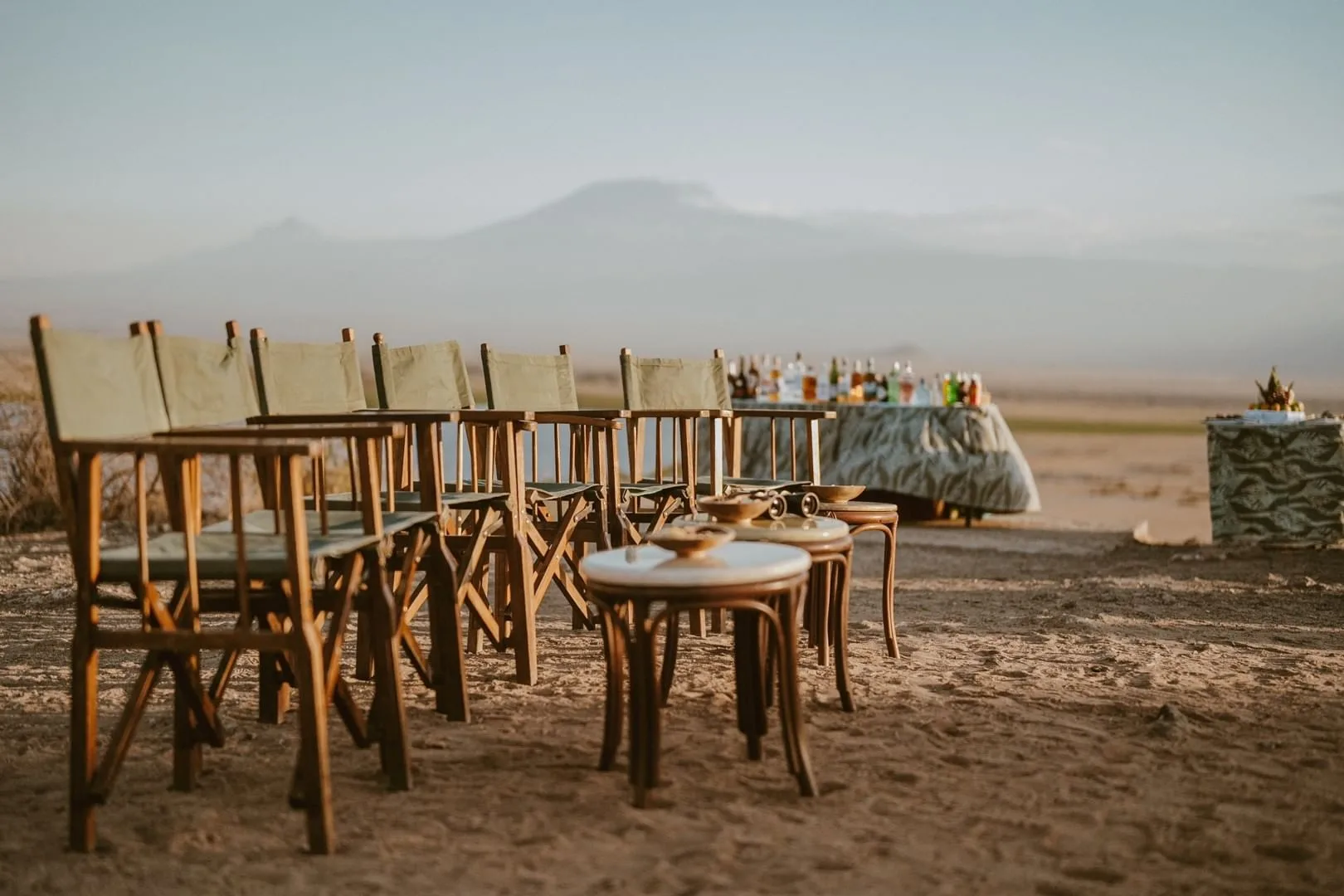 Director's chairs set up for a sundowner drink, with Mount Kilimanjaro rising in the distance.