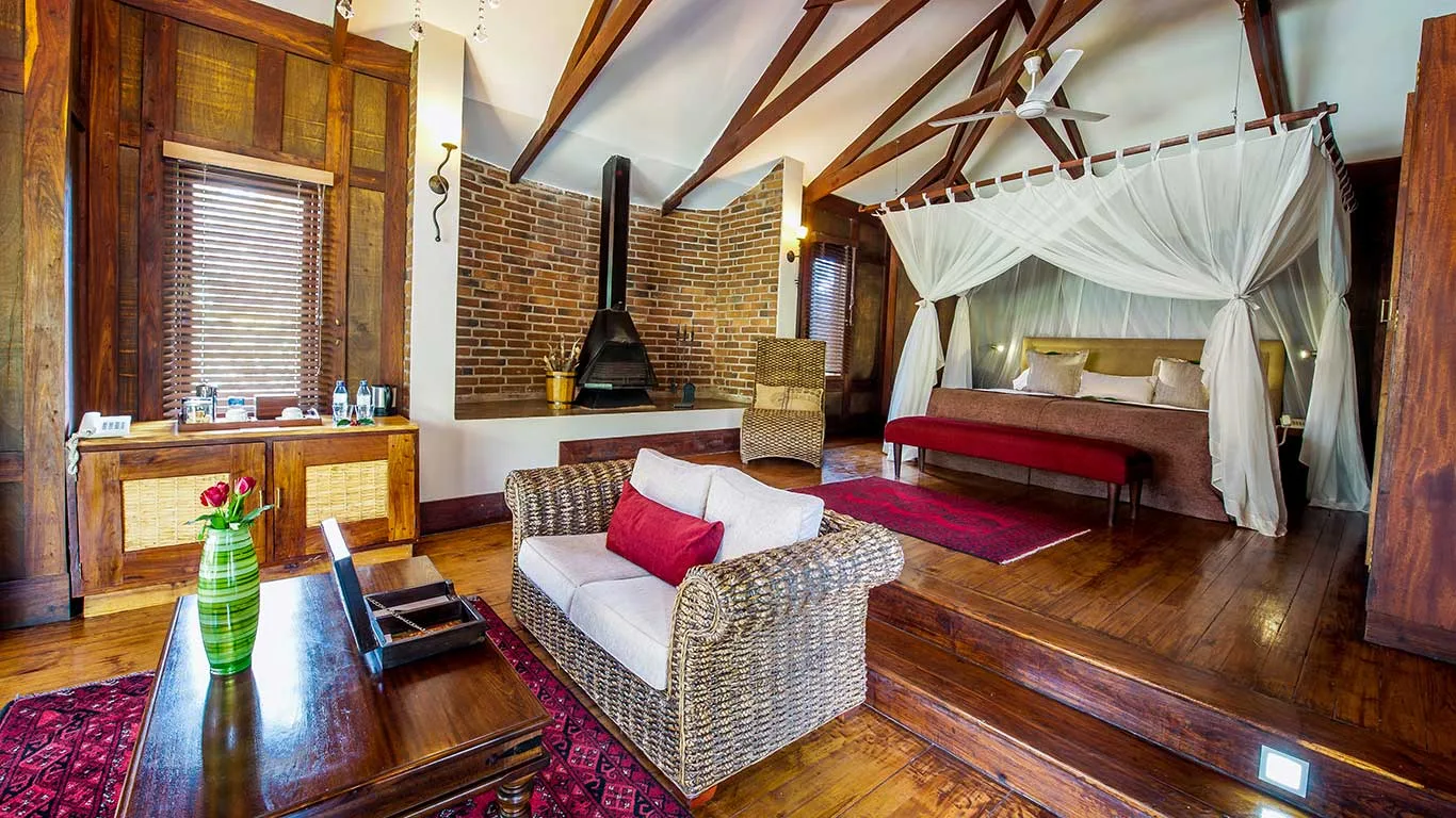 A Plantation Room, with its signature four-poster bed and log fireplace.