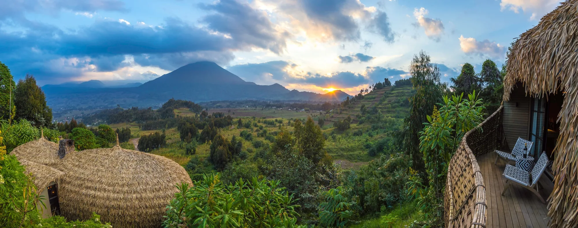 Mount Bisoke catches the last light, seen from a private villa deck.