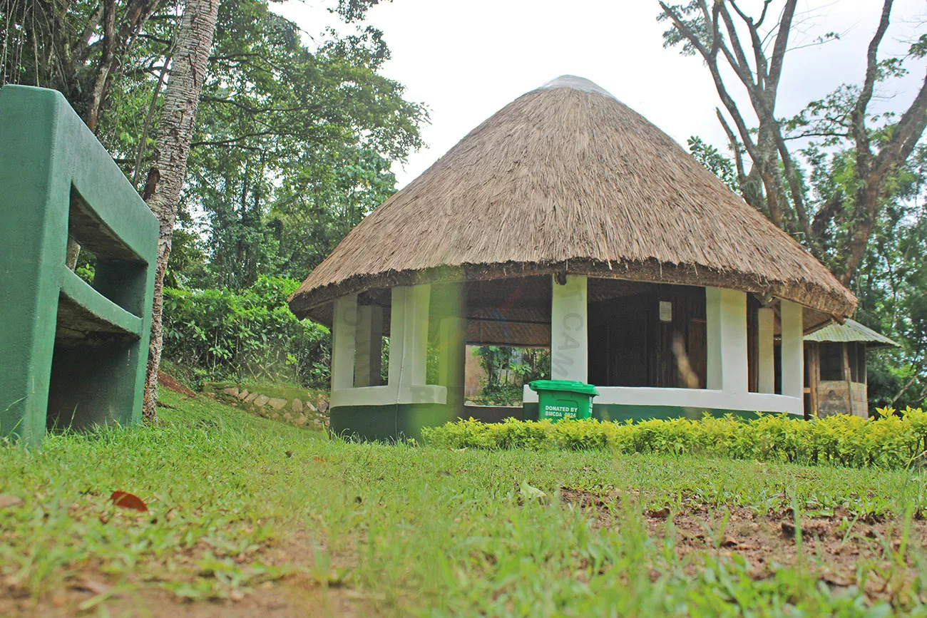 A traditional thatched-roof gazebo used as a communal gathering space.