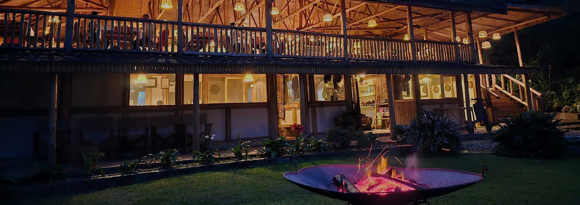 The lodge's central lounge and fireplace area, lit up at dusk.