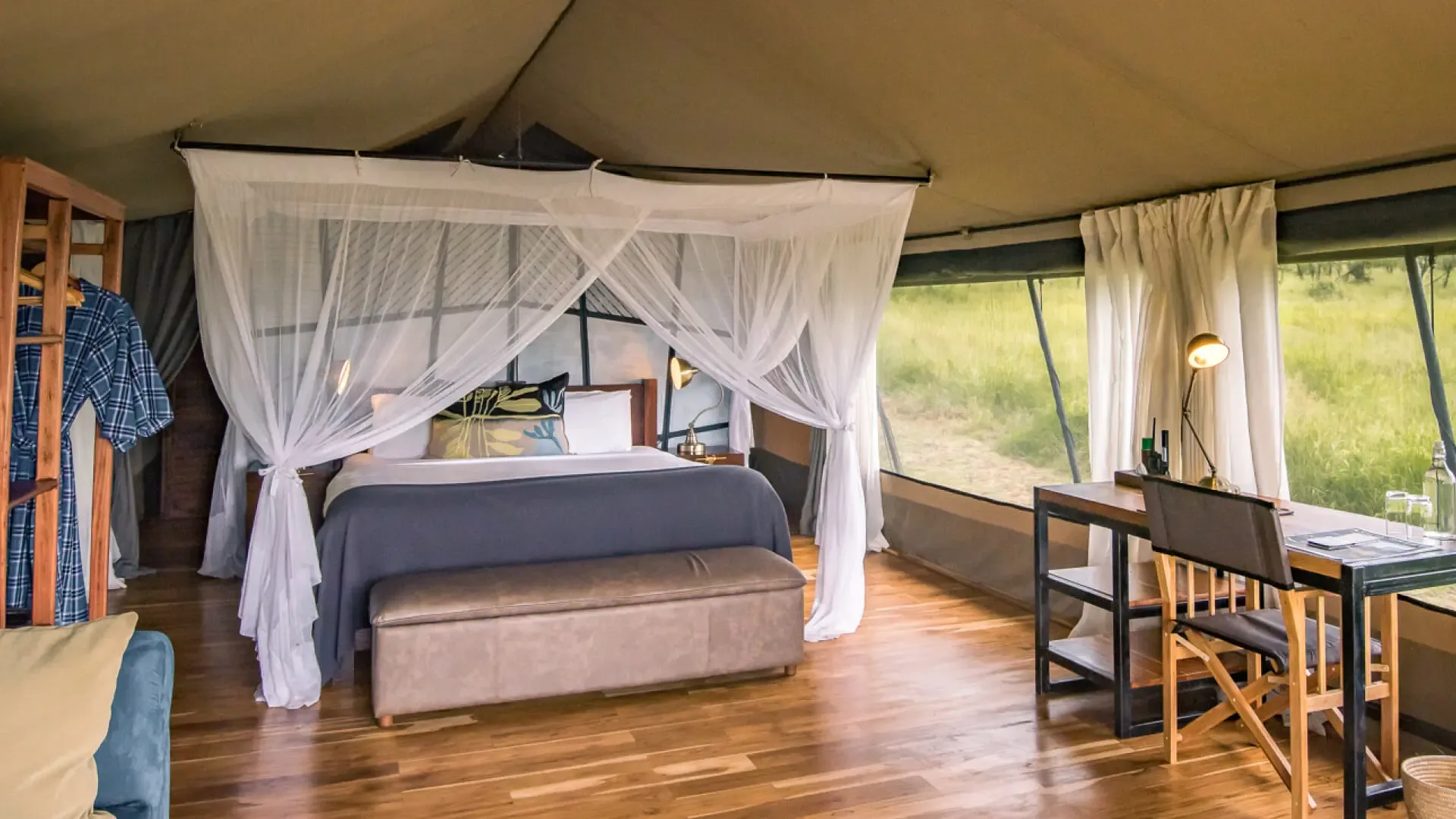 Inside a Dunia Camp guest tent, styled with an en-suite bathroom and private veranda.
