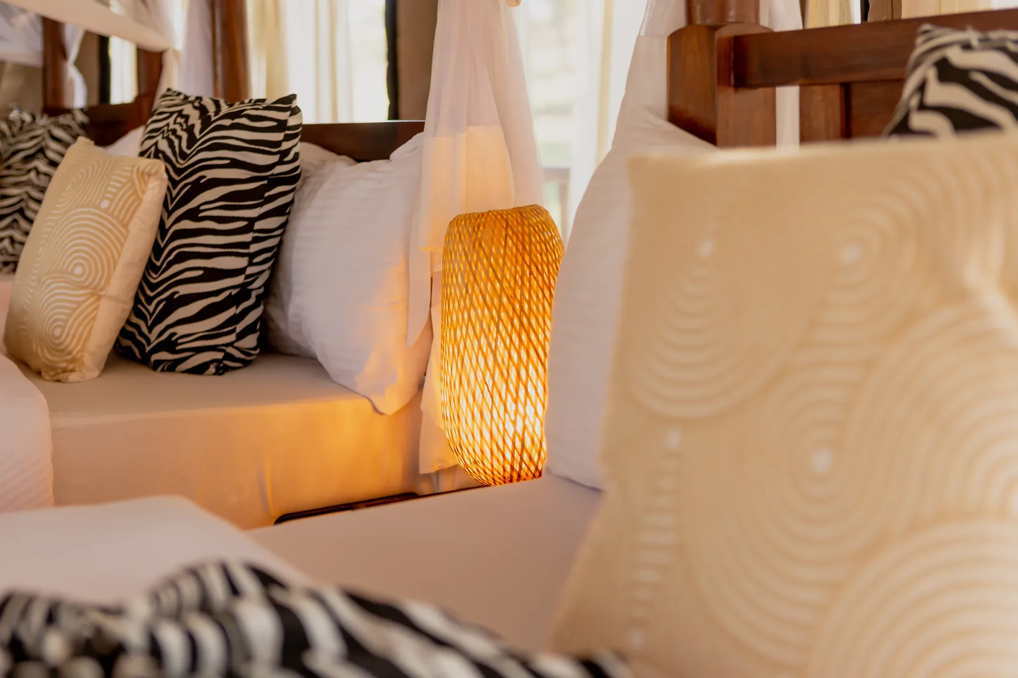 African-print textiles and warm lantern light define the tent interiors.