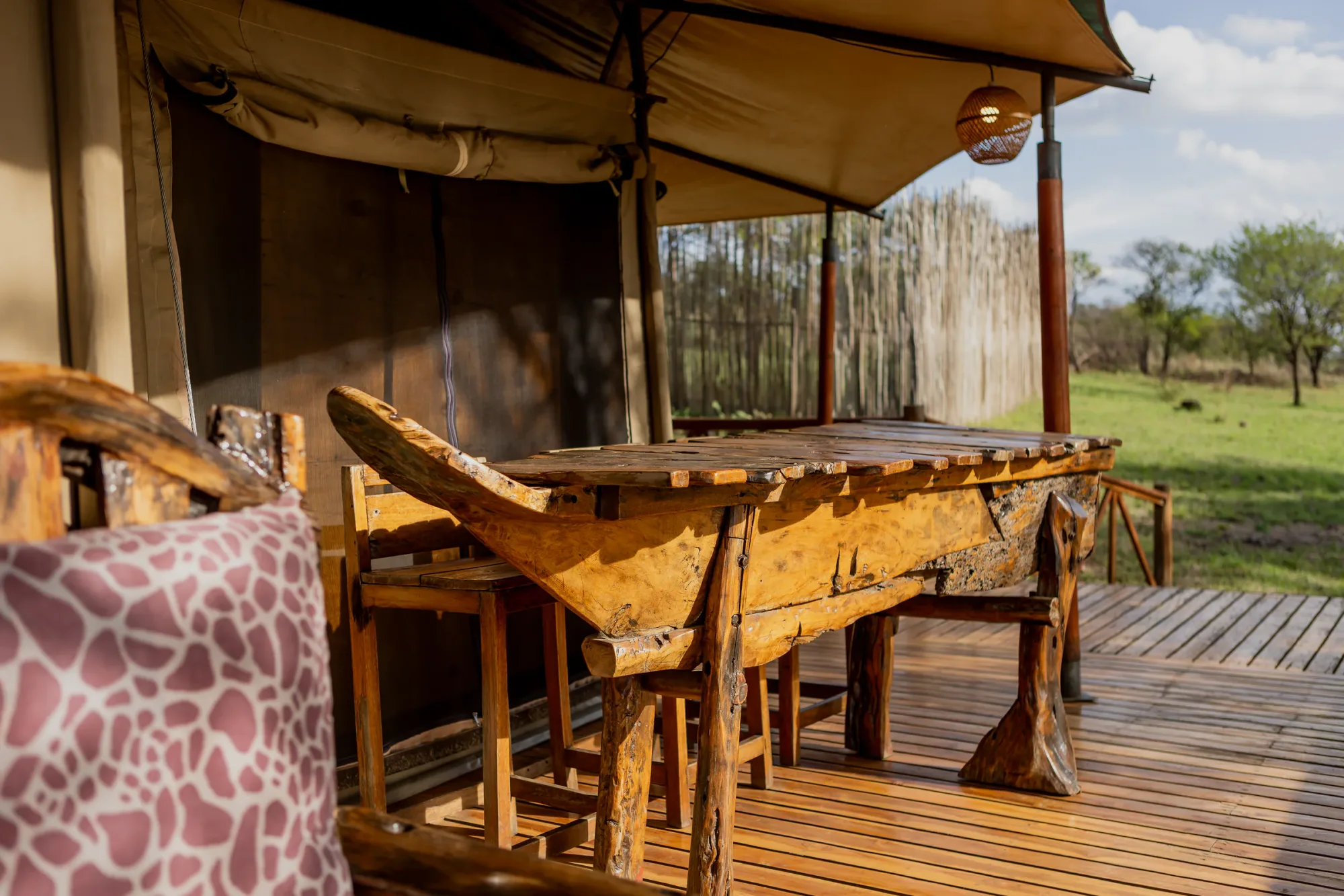 A hand-carved bar counter anchors the camp's deck overlooking the plains.