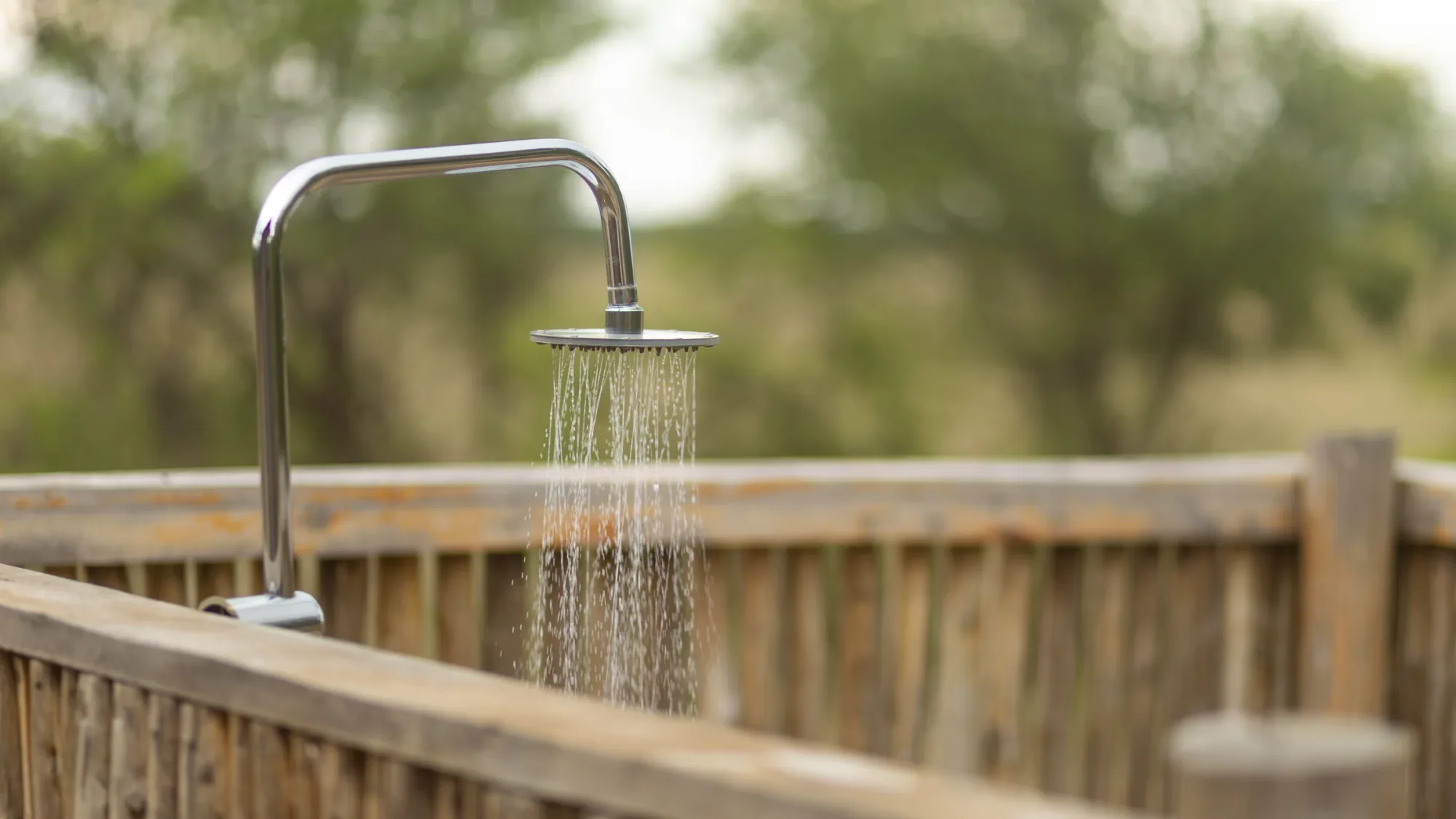 En-suite bush showers open onto the surrounding woodland.