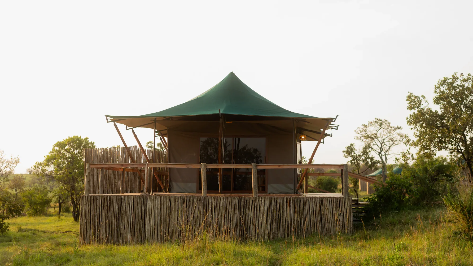 Spacious canvas tents sit on raised decks within the migration corridor.