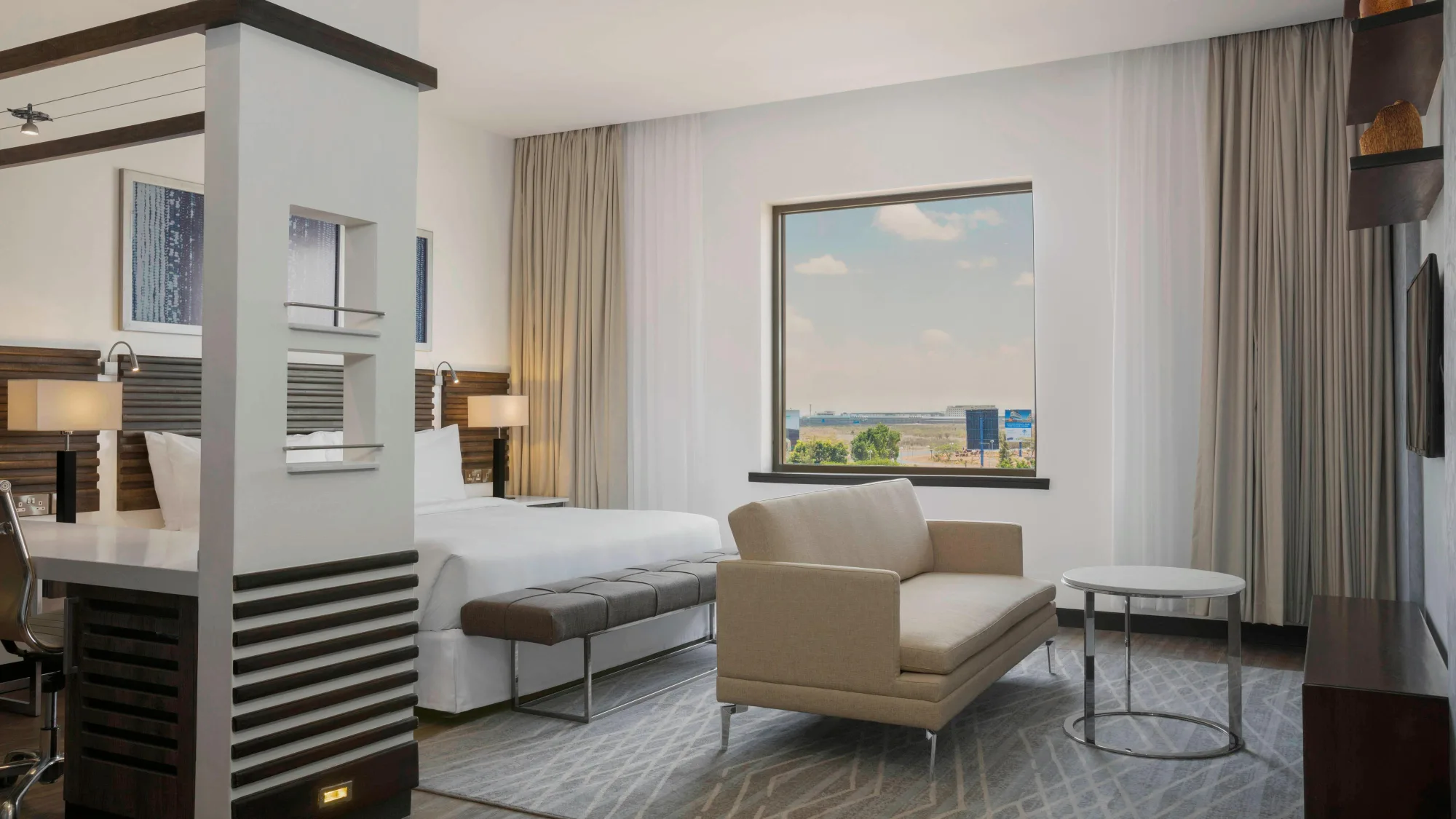 A deluxe king room with contemporary furnishings and airport views
