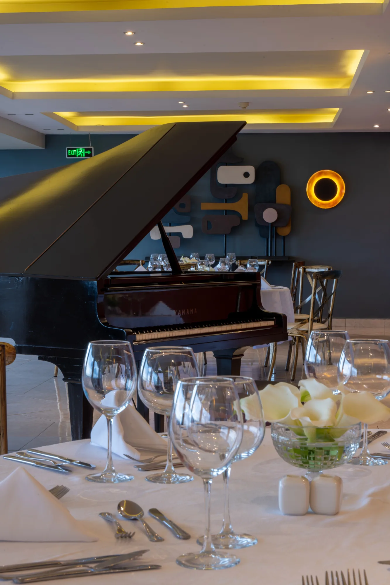 The hotel restaurant, set for dinner beside its grand piano.