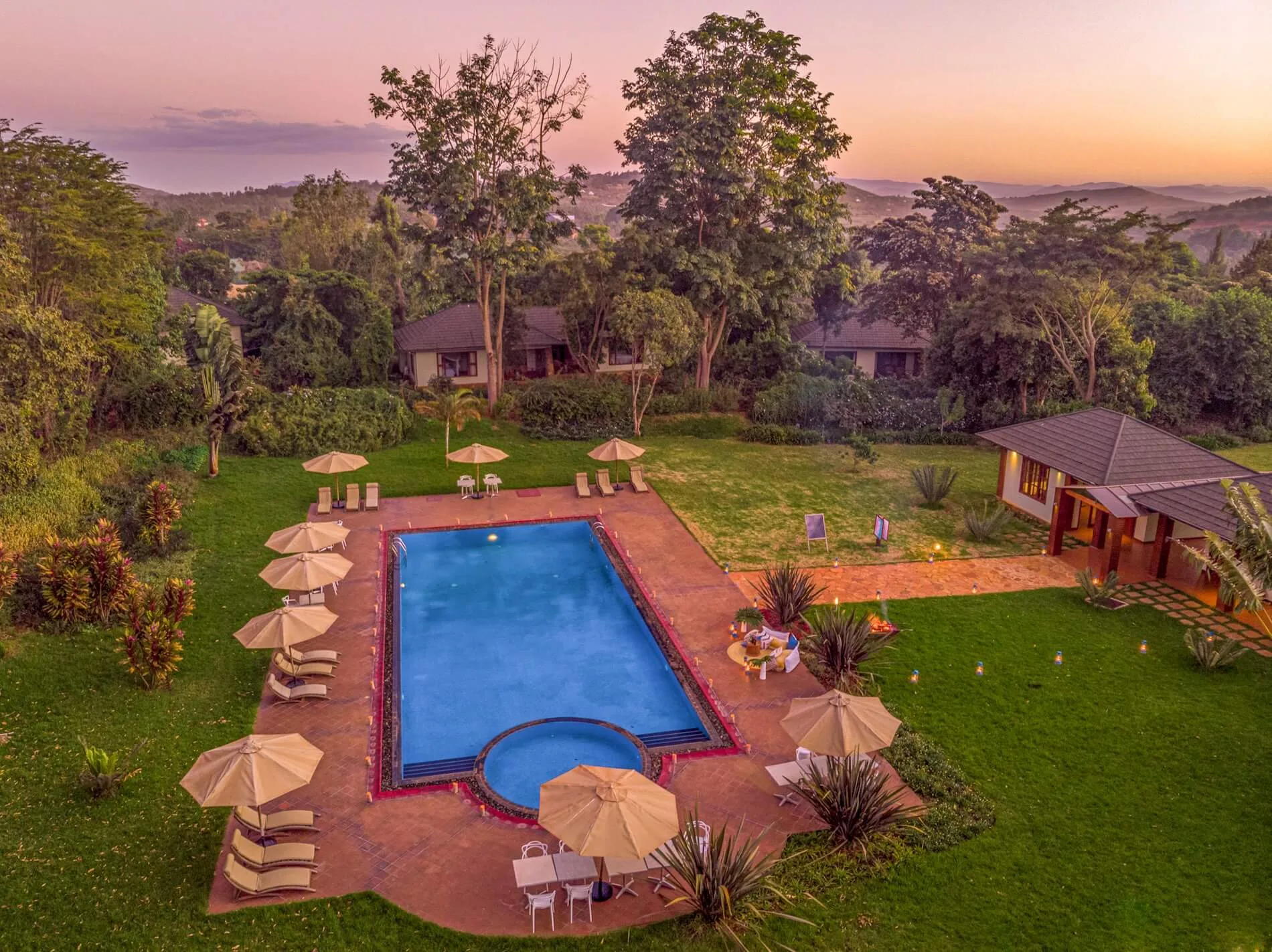 The lodge grounds at sunset, with rolling Karatu farmland stretching to the horizon.