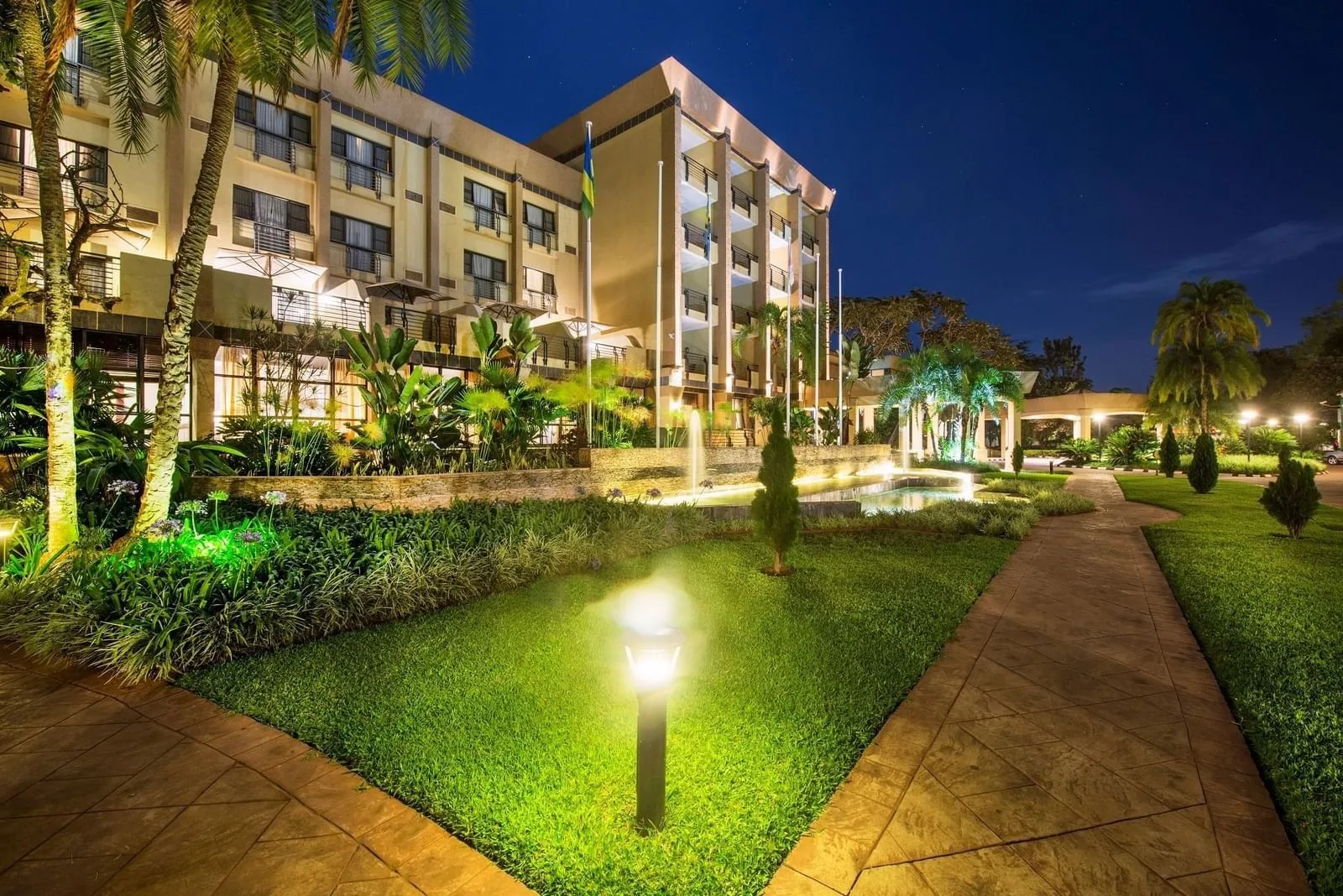 The hotel's tropical grounds and fountain courtyard at twilight.