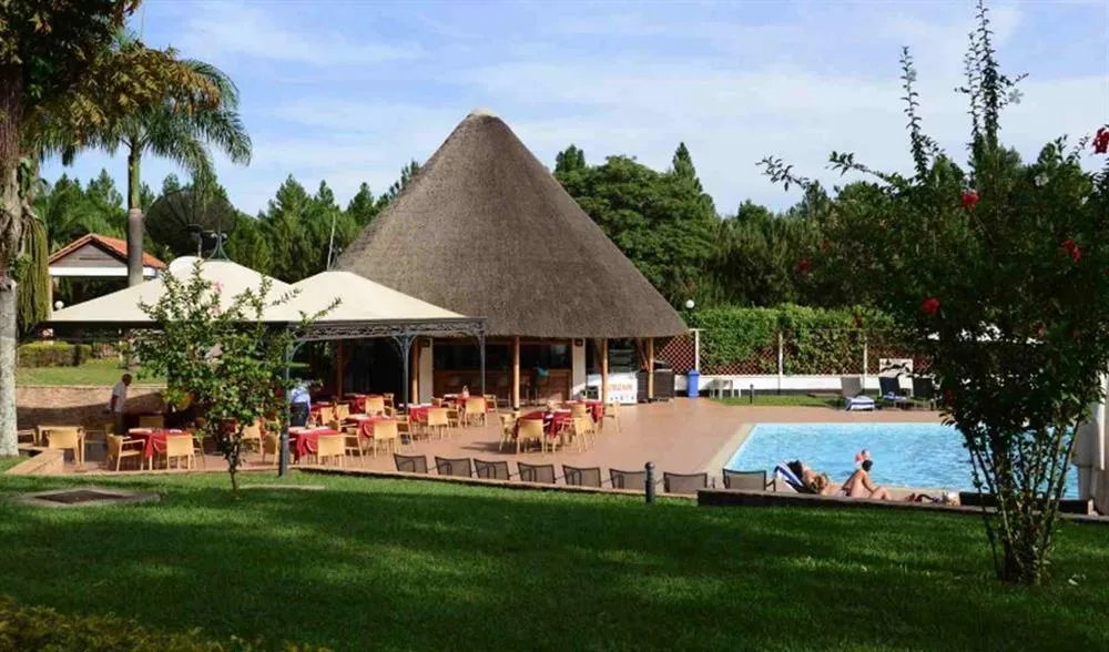 Poolside dining pavilion, shaded by a traditional thatched roof