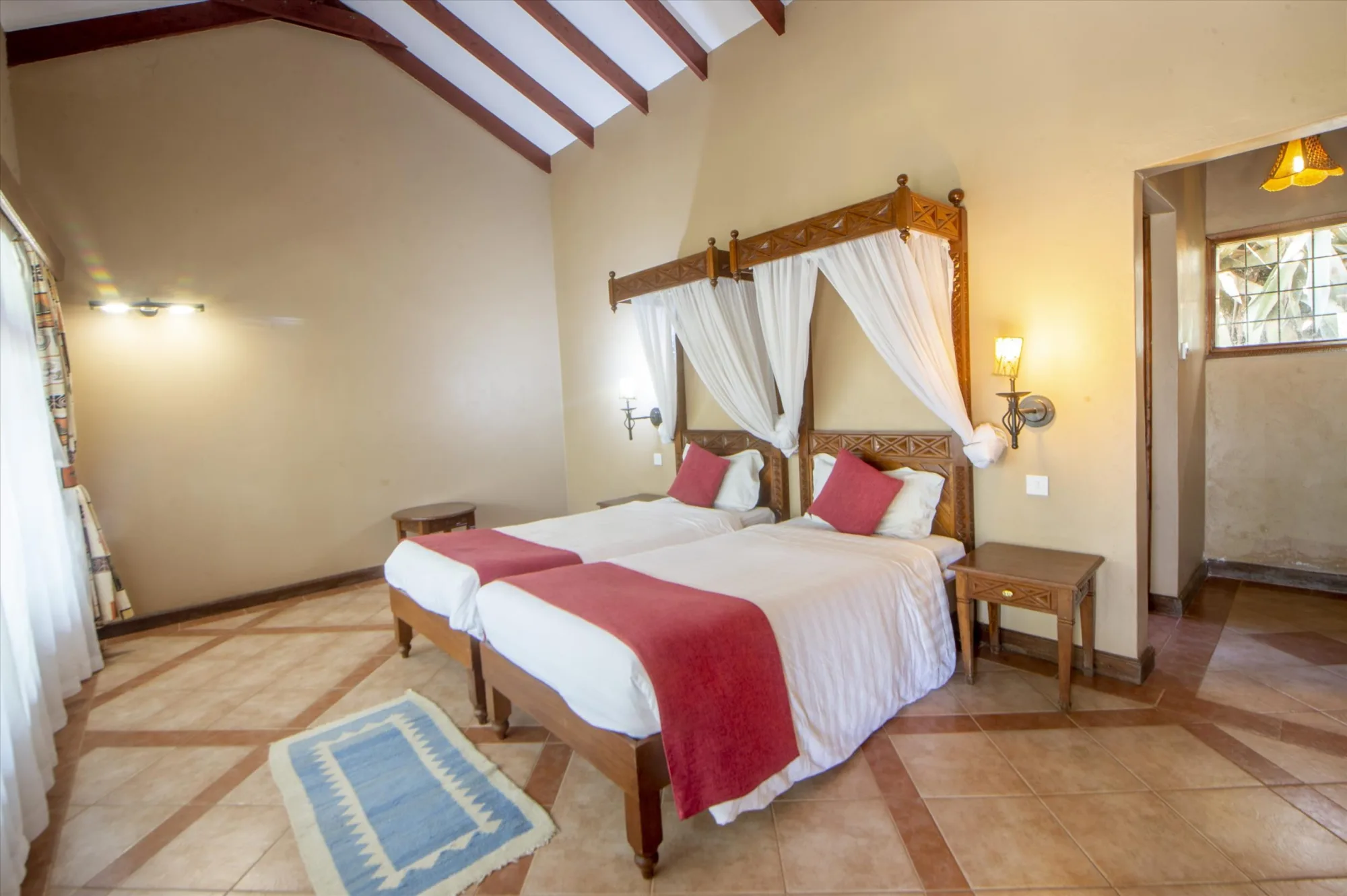 A spacious twin room with traditional carved wood furnishings