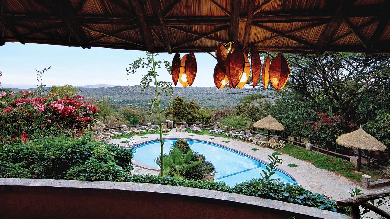 Sundowner views stretch across the Oloolaimutiek hills toward the Mara plains.
