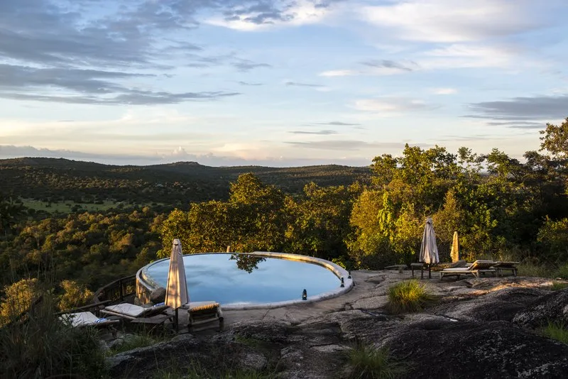 The rock-edge infinity pool looks out across miles of Lake Mburo bushland.