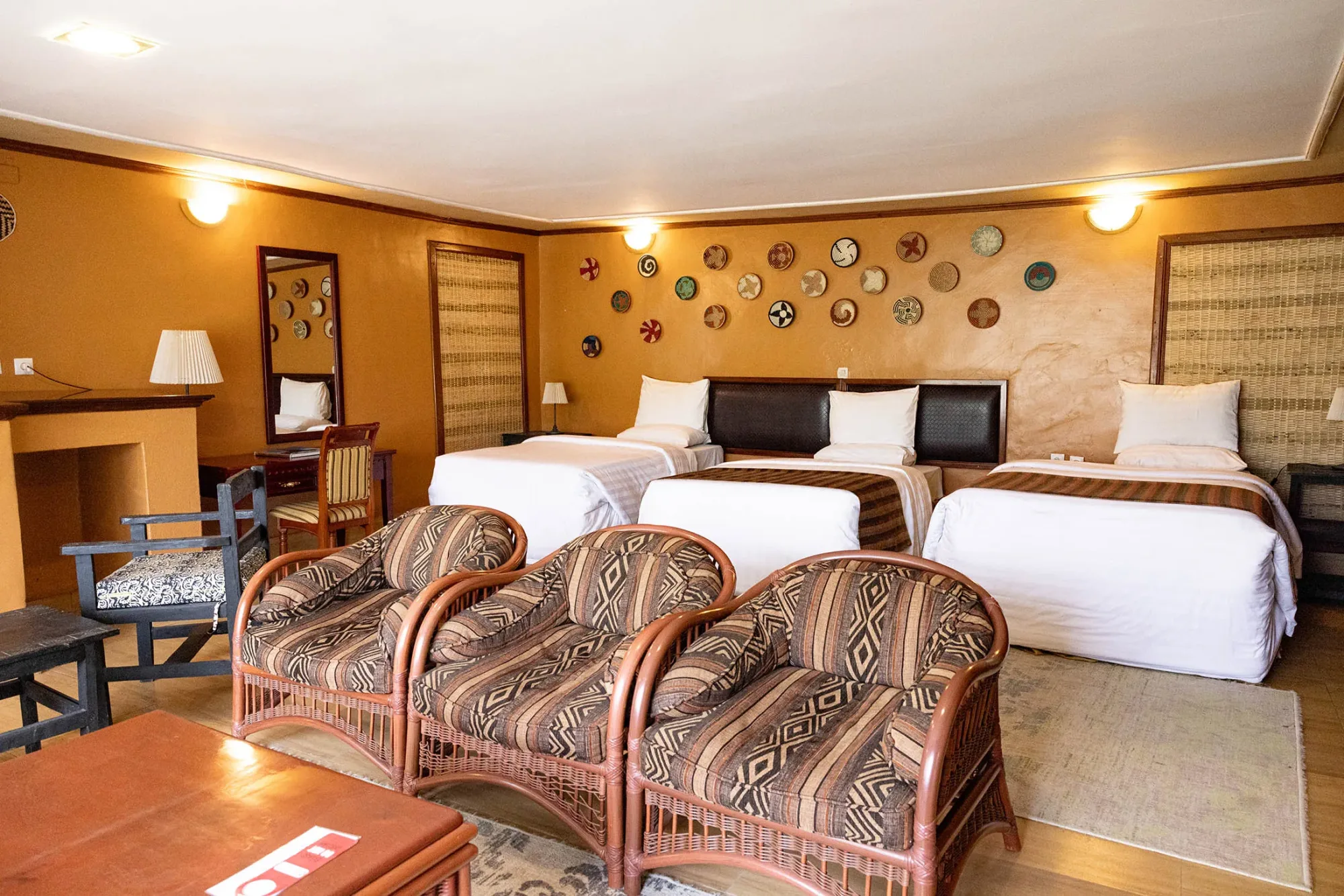 A triple room decorated with traditional Rwandan woven baskets and rattan seating.