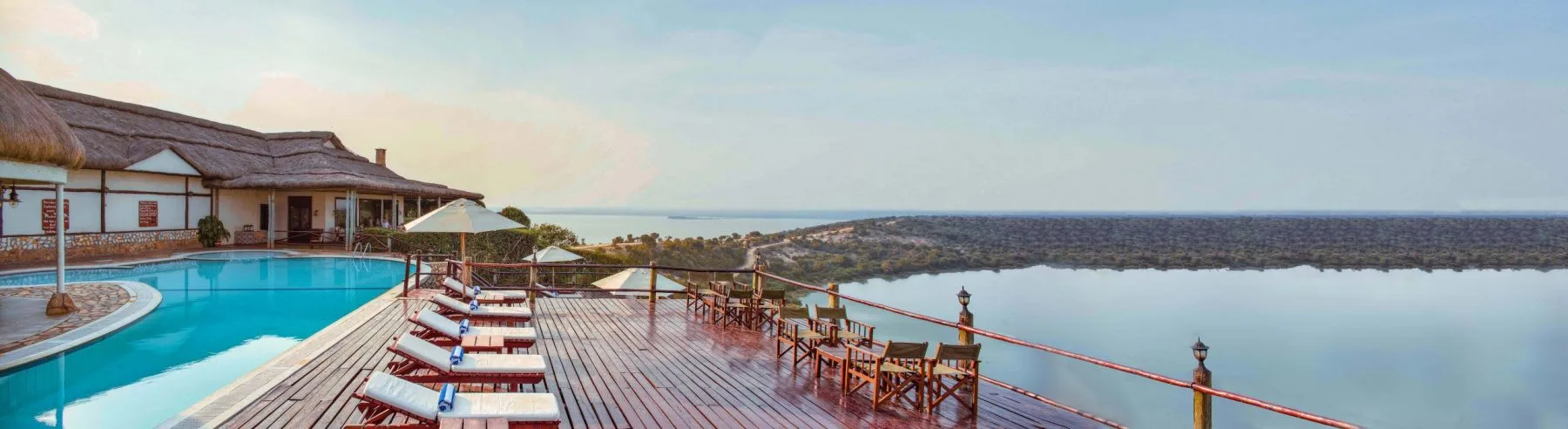 The lodge's terrace and pool deck at dusk, overlooking the channel separating Lake Edward and Lake George.