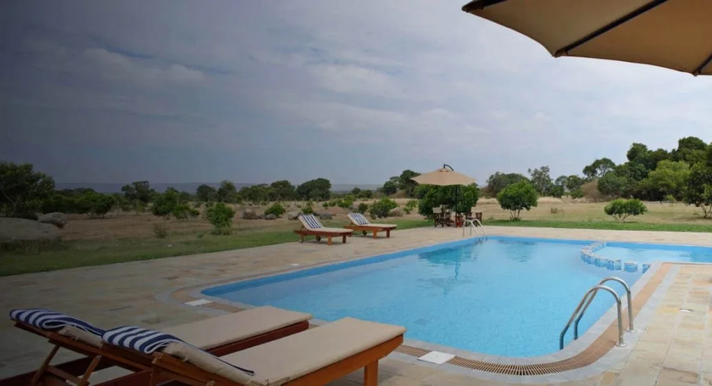 The camp's pool deck looks out over open grassland in the Mara's Lemek Conservancy.