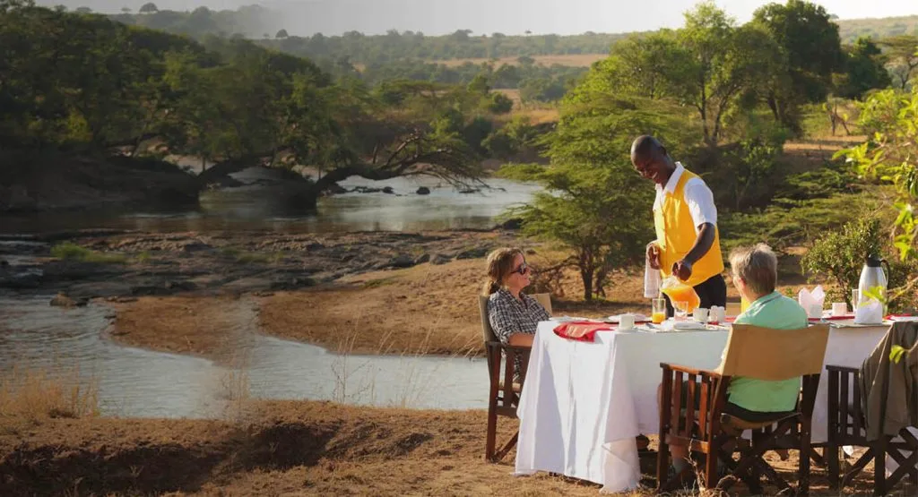 Breakfast is served beside the river within the camp's private conservancy.