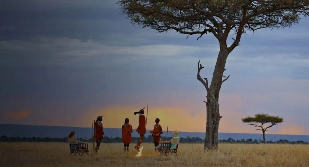 Cultural performances by Maasai guides are a signature evening experience at this Maasai-crafted camp.