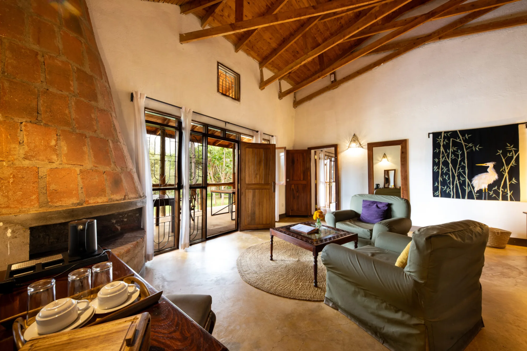 The main lounge's exposed-brick fireplace and vaulted wooden ceiling set a cozy, colonial-farmhouse tone.