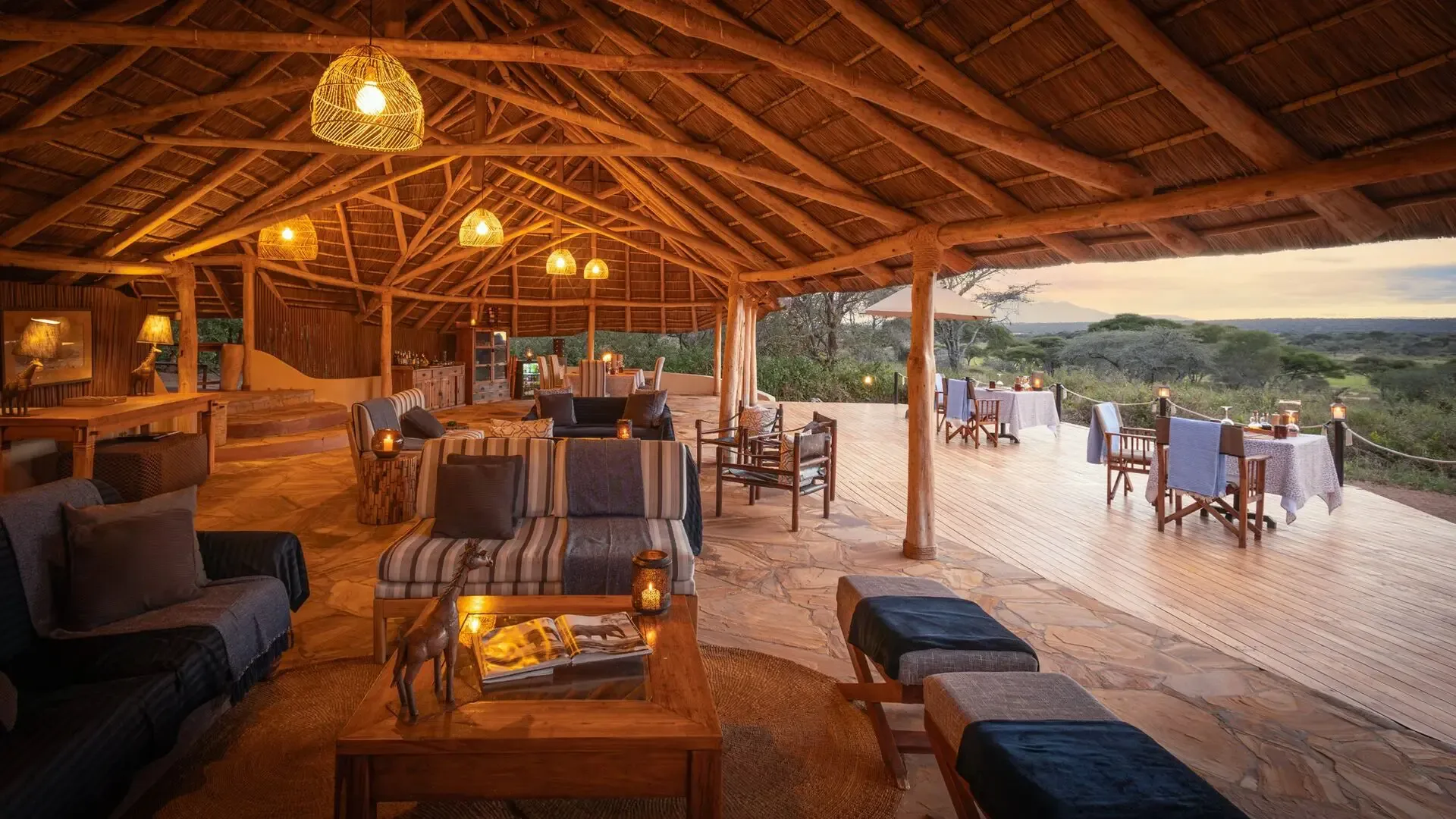 Open-air dining beneath thatch, with sweeping views over Tarangire.
