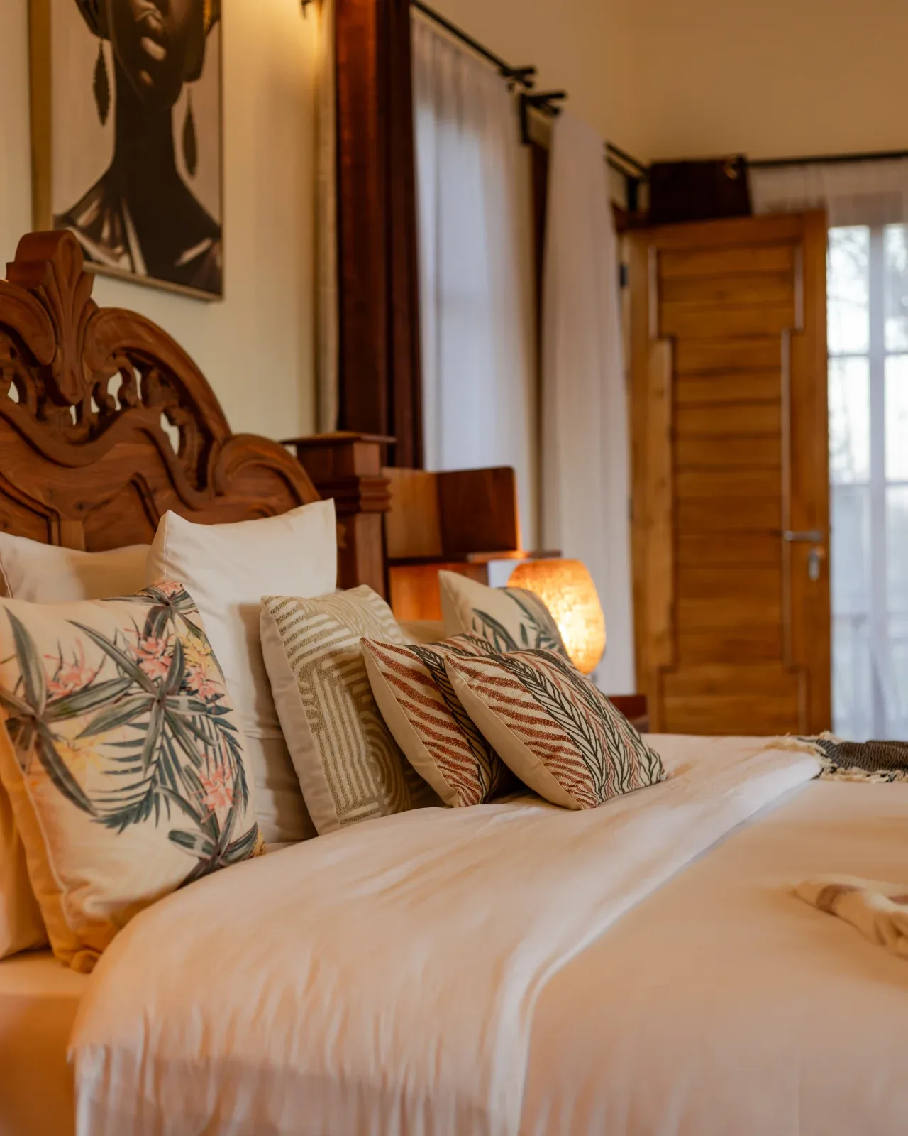 Rooms pair hand-carved local furniture with warm, earthy textiles.