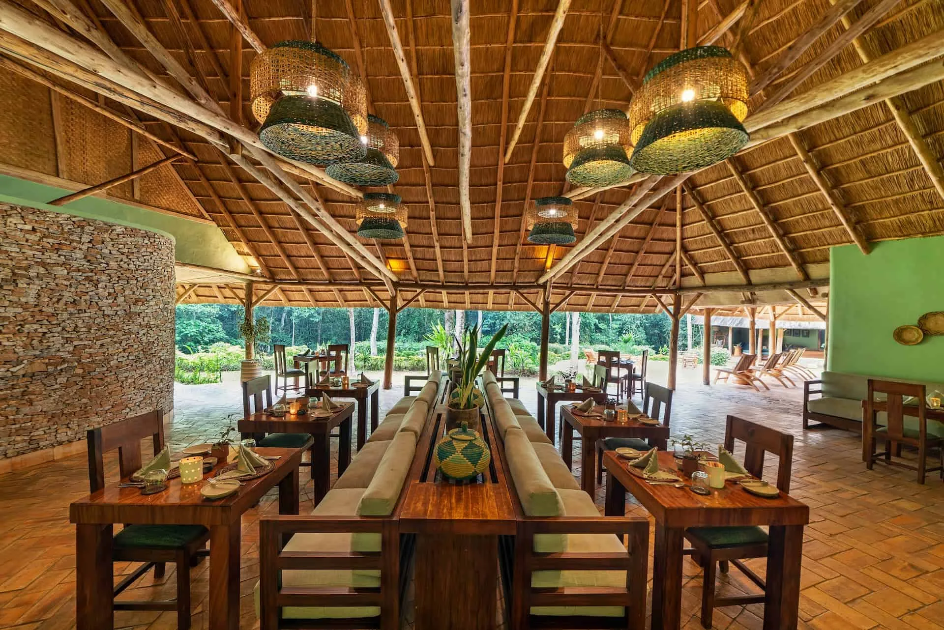 The dining pavilion opens directly onto the surrounding forest.