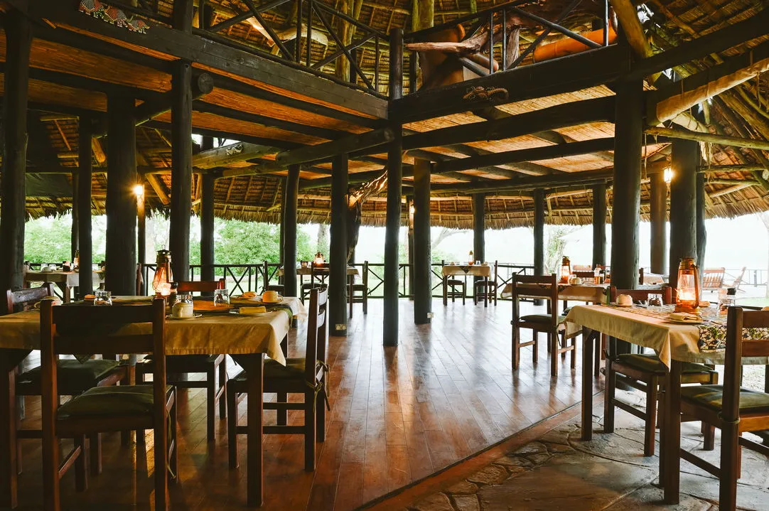 Breakfast under thatch, with the Rufiji River unfolding beyond the rail.