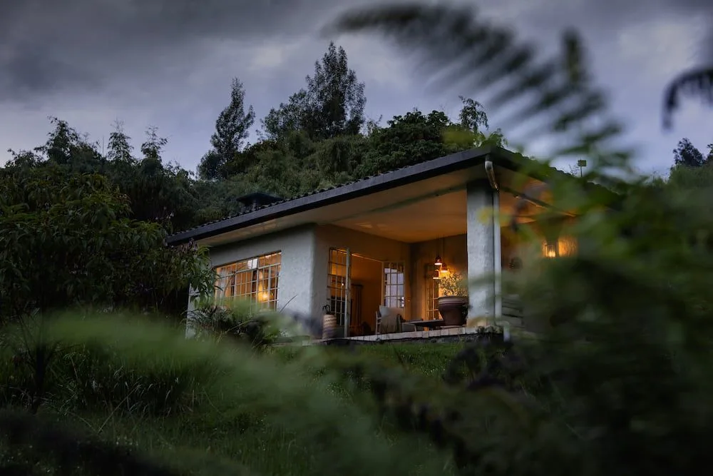 One of the lodge's nine stone cottages, lit up as evening falls over Volcanoes National Park.