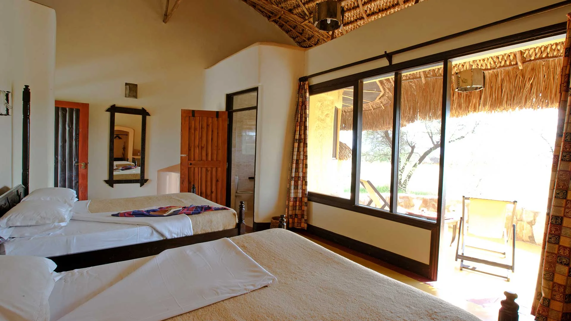Spacious twin rooms open directly onto a private veranda facing the bush.