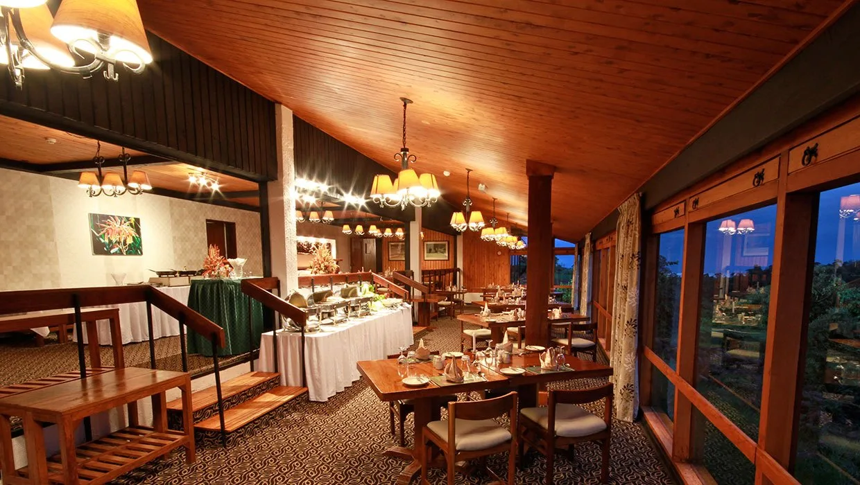 Guests dine beneath timber beams in The Ark's candlelit dining room.