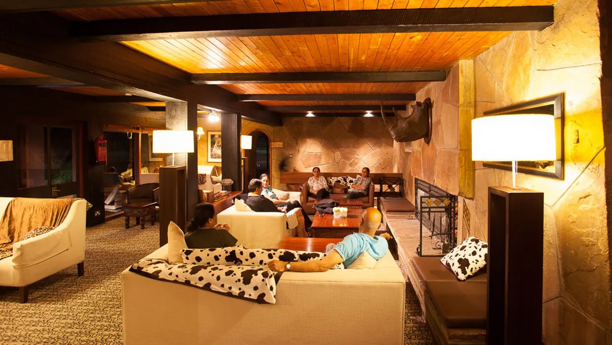 A stone fireplace and deep sofas make the lounge a warm retreat after a day of wildlife watching.