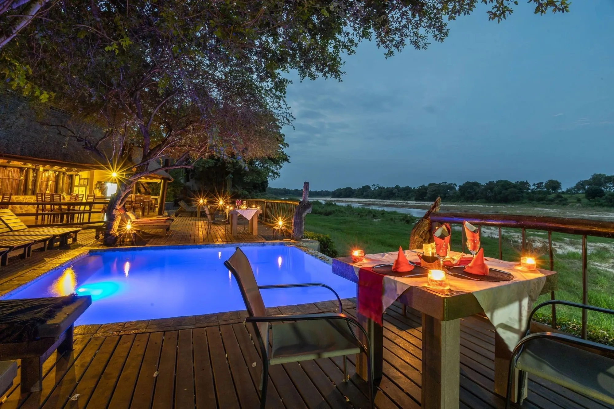 Private candlelit dining beside the pool as the bushveld falls quiet at night.