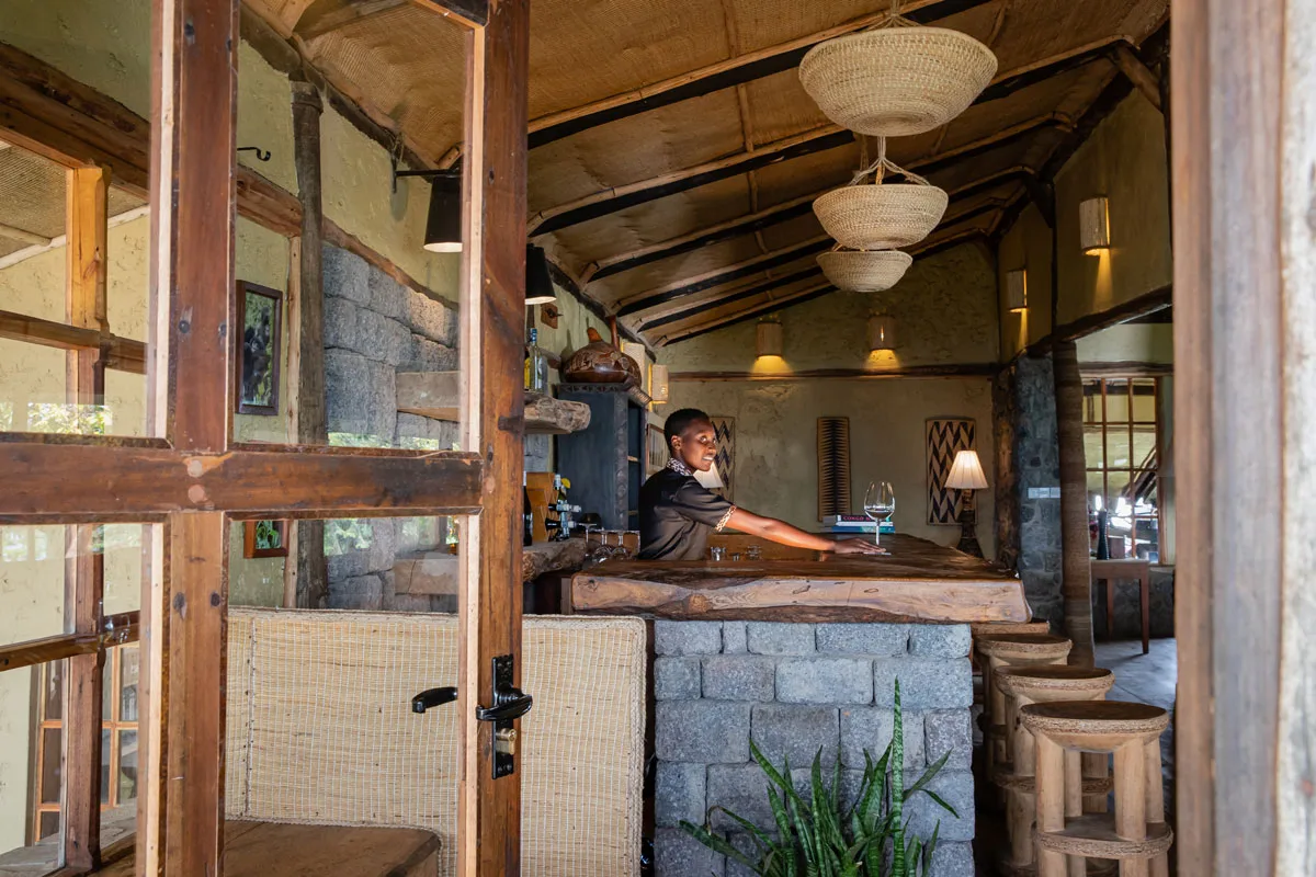 The lodge bar, built from volcanic stone and timber under woven basket lighting.