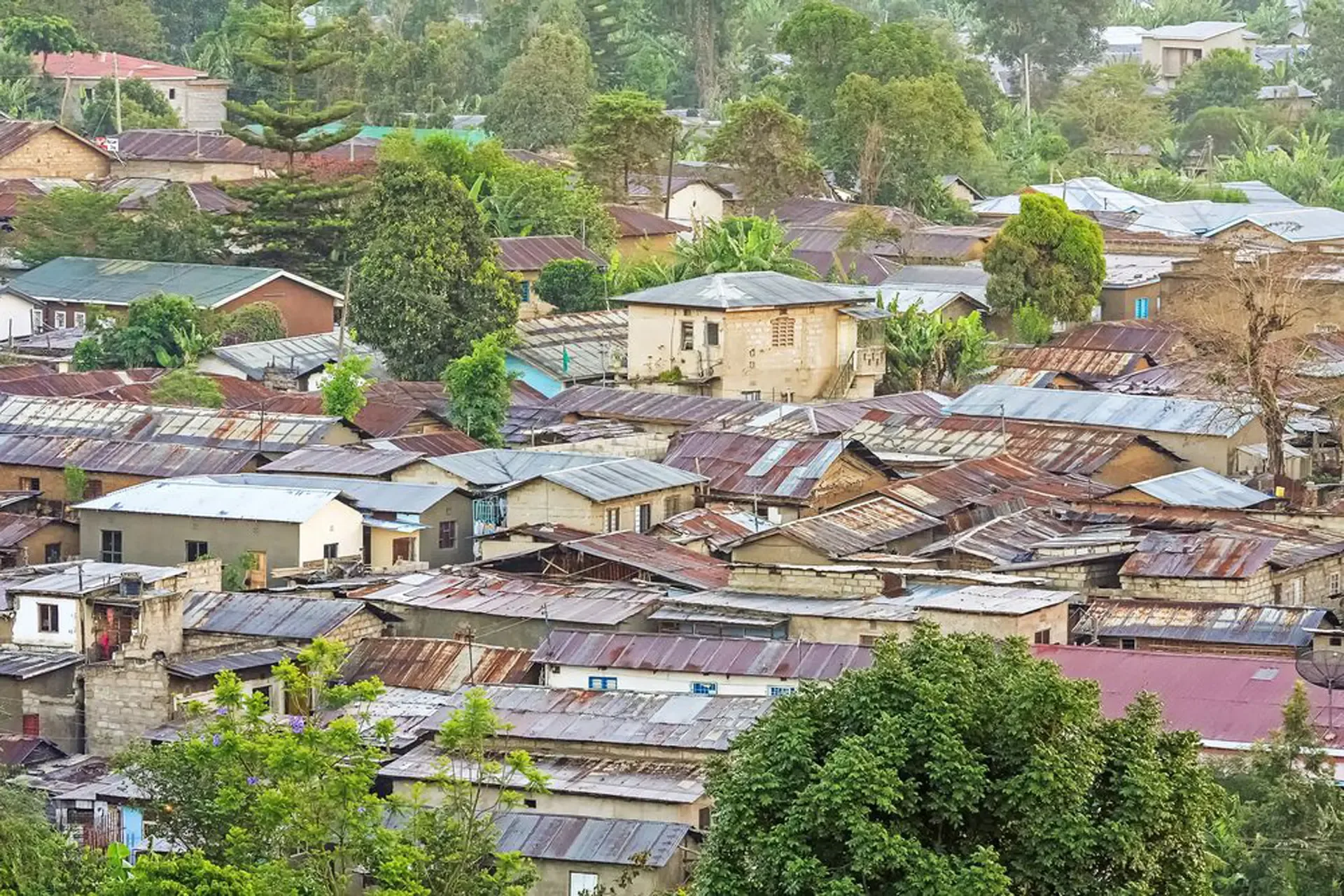Rusted metal roofs pack a hillside neighbourhood in Moshi, Tanzania.