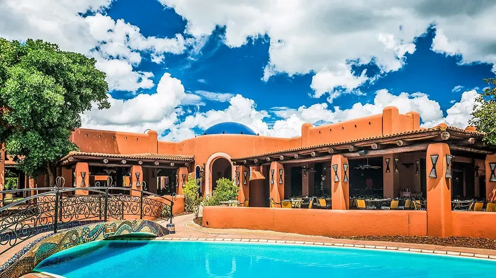 The pool and terracotta architecture at Avani Victoria Falls Resort in Zambia.