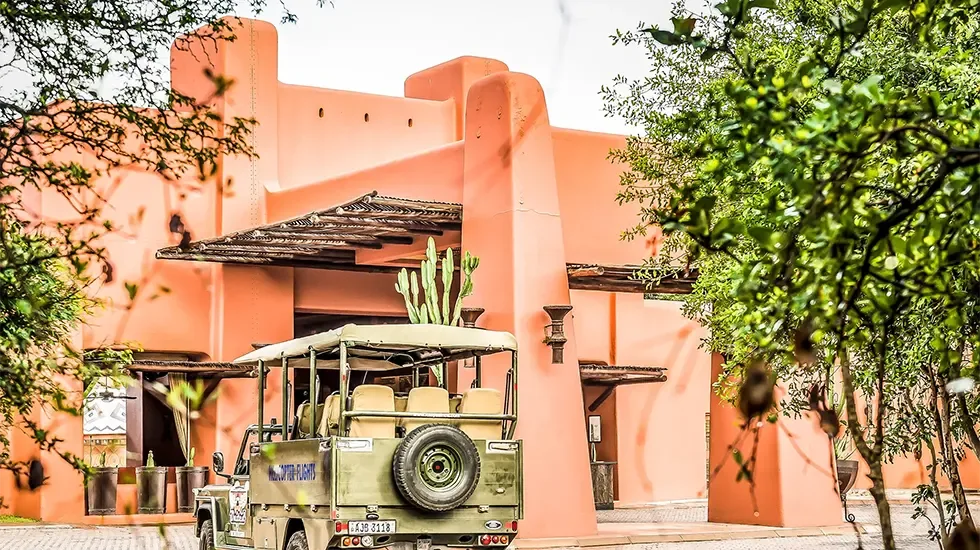 An open safari vehicle waits outside Avani Victoria Falls Resort in Zambia.