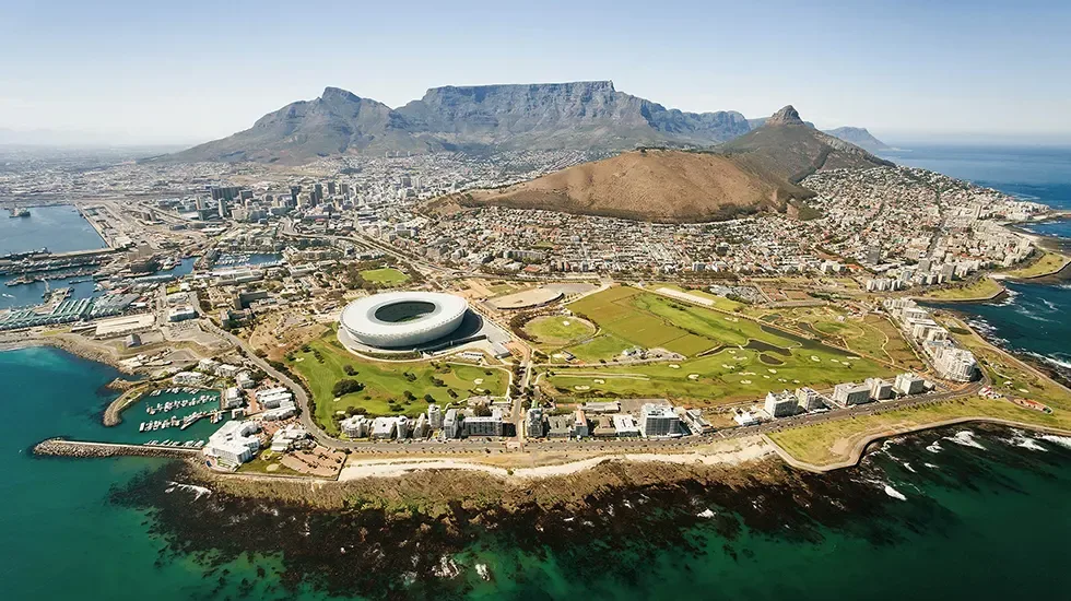 Cape Town from above, with Table Mountain rising behind the city and harbour.