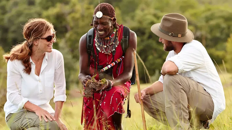 A guide shares a light moment with guests on a walking safari in Kenya.