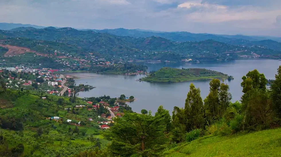 Red-roofed houses and green hills above the water in Gisenyi, Rwanda.