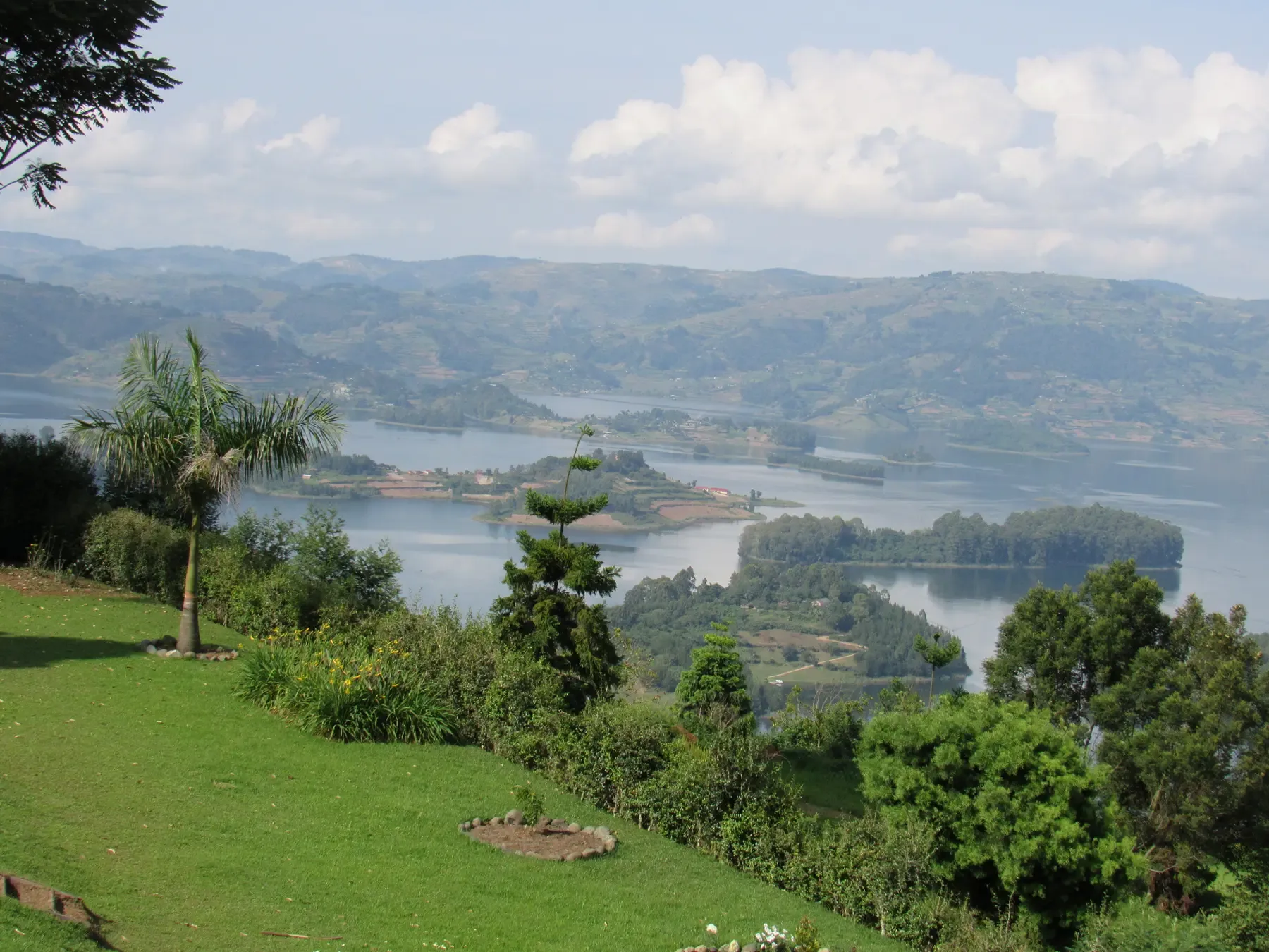 A green lawn above the water at Gatatu, with islands and hills stretching into the distance.