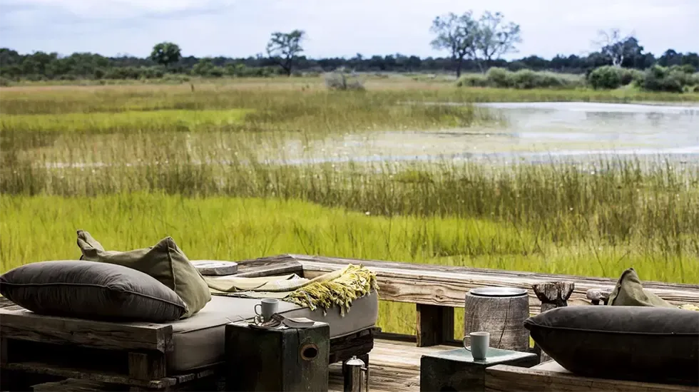 Cushioned deck seating looking out over the reeds and water of the Khwai Concession, Botswana.