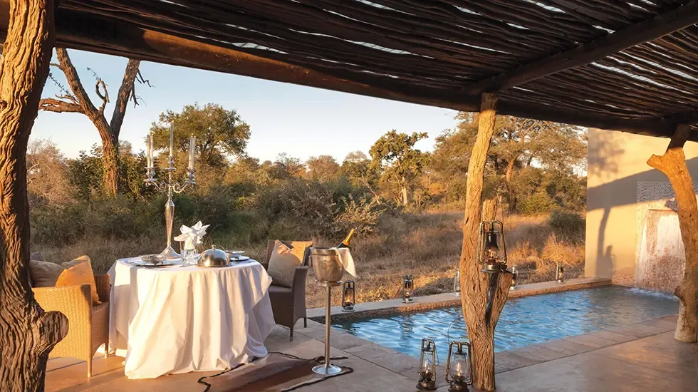 A private dinner laid beside the pool at Kings Camp, South Africa.