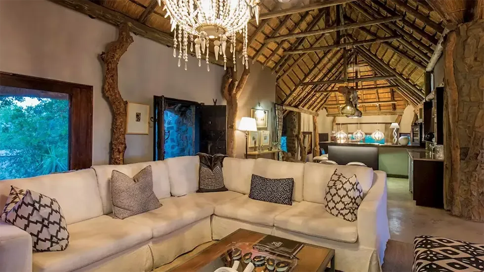 The lounge at Leopard Hills, Sabi Sand, where a chandelier hangs above a deep cream sofa.