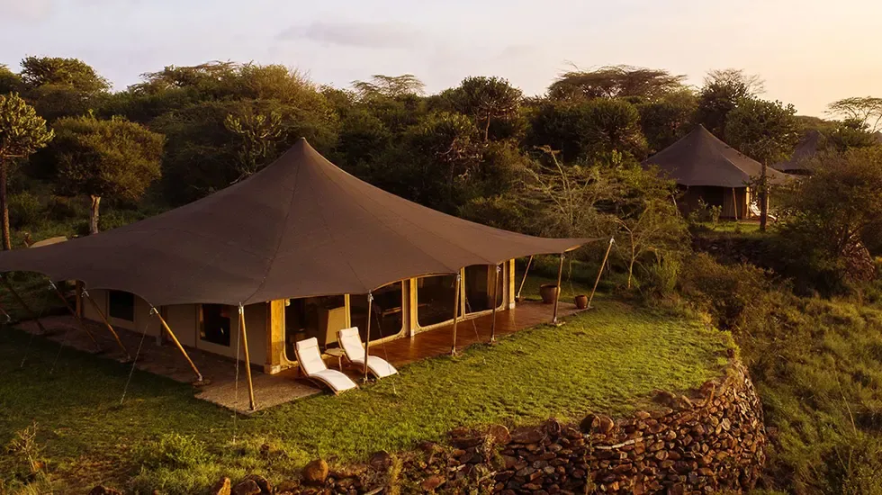 Evening light on a safari tent at Loisaba Tented Camp, Kenya, with loungers on the lawn.