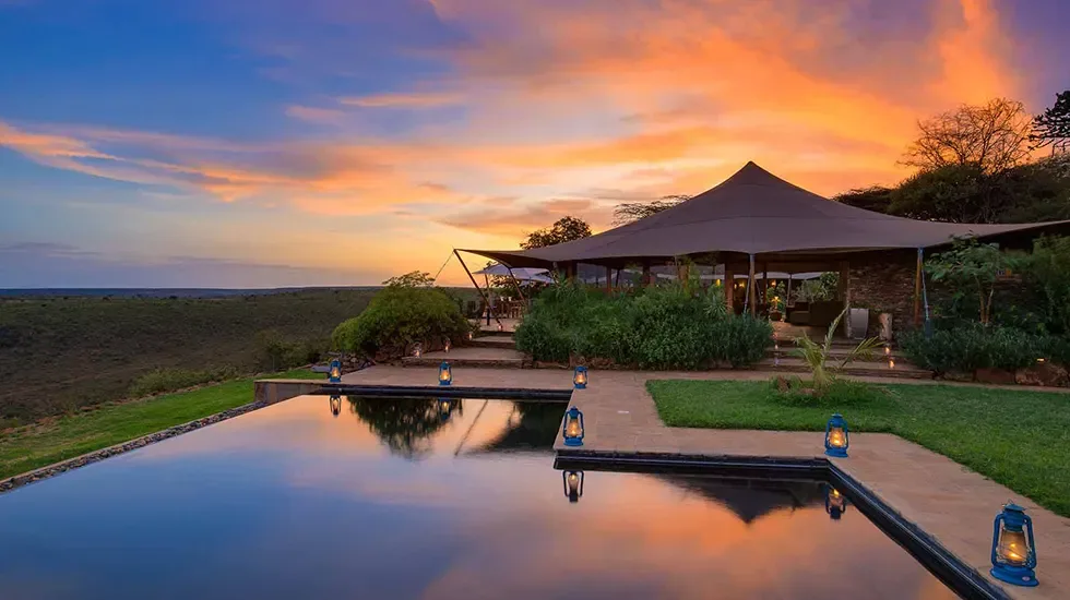 Lanterns glow at dusk beside the pool at Loisaba Tented Camp, Kenya.