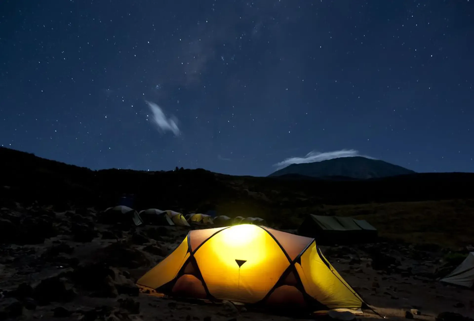 A lit tent beneath the stars at camp on Mount Kilimanjaro, Tanzania.