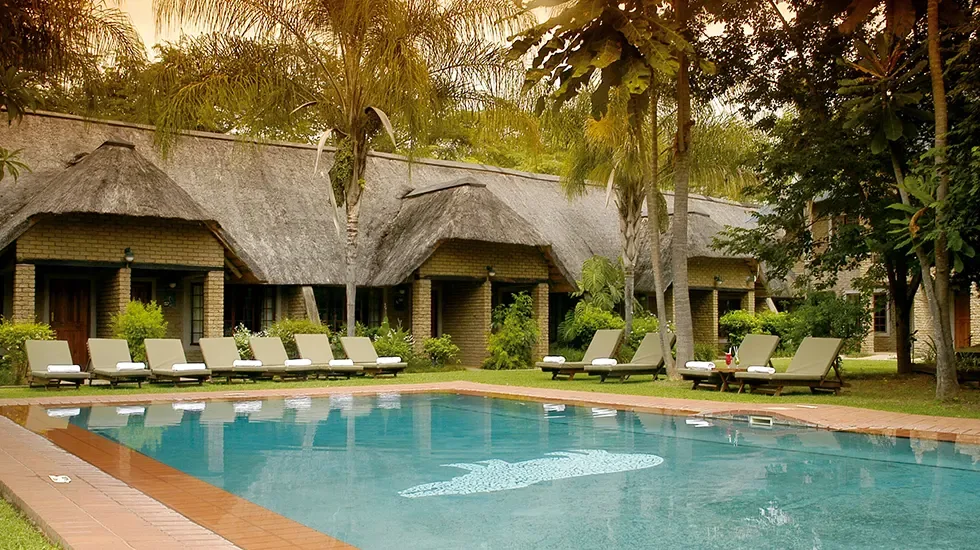 Loungers and palm shade beside the pool on the Panorama Route in South Africa.