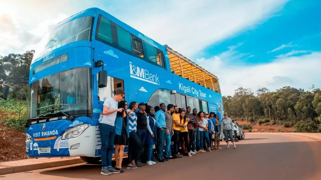 Travellers gathering beside the Kigali City Tour bus in Rwanda before setting off.